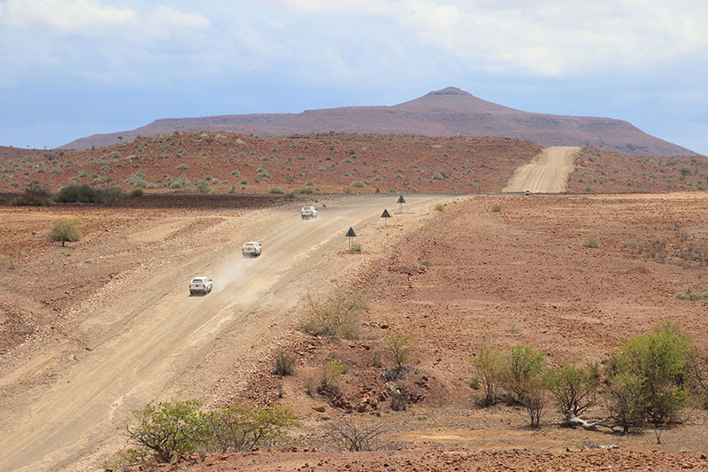 Convoi de véhicules humanitaires circulant sur une piste désertique